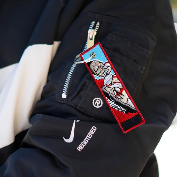 Dandadan embroidered jet tag keychain, Okarun key tag, Momo Ayase anime keychain, Yukinobu Tatsu manga accessory, Japanese anime key tag, otaku embroidered keychain, anime merch gift, Harajuku streetwear accessory, Tokyo street fashion keychain, aesthetic anime jet tag, cosplay bag charm, anime convention accessory, manga collector gift, JDM style embroidered tag, luggage tag, keyring for anime fans, Dandadan cosplay prop.