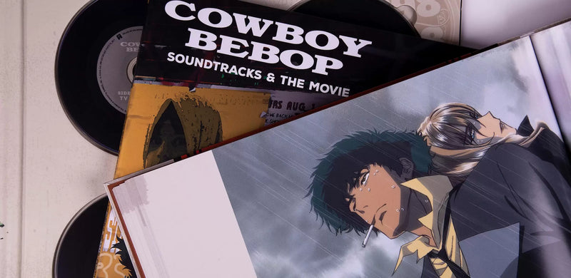 Cowboy Bebop 20th Anniversary Ultimate Edition collector’s box set featuring the complete anime series and movie on Blu-ray, three official Yoko Kanno soundtracks (Soundtrack 1, No Disc, and Blue), a 120-page hardcover art book with rare concept designs, all housed in a numbered retro vinyl-style flight case—this once-in-a-lifetime release is a true collector’s grail for those who grew up with Spike, Jet, Faye, Ed, and Ein; more than a box set, it’s a piece of anime history for fans who remember.