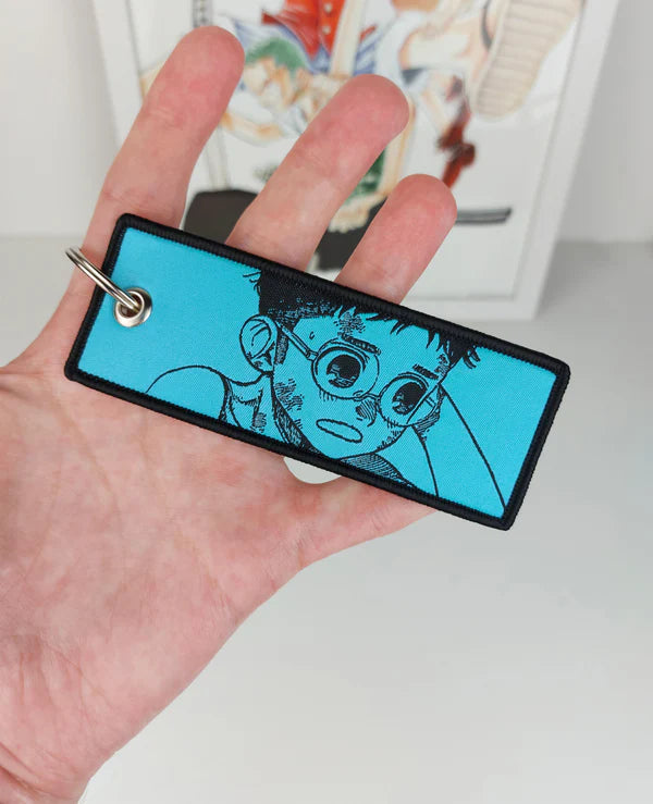 Dandadan embroidered jet tag keychain, Okarun key tag, Momo Ayase anime keychain, Yukinobu Tatsu manga accessory, Japanese anime key tag, otaku embroidered keychain, anime merch gift, Harajuku streetwear accessory, Tokyo street fashion keychain, aesthetic anime jet tag, cosplay bag charm, anime convention accessory, manga collector gift, JDM style embroidered tag, luggage tag, keyring for anime fans, Dandadan cosplay prop.