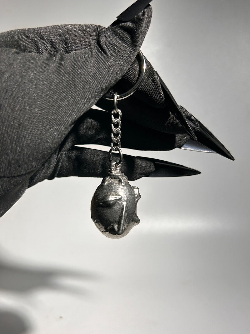 Handcrafted Behelit Keychain – Cast from solid, lead-free 97LF alloy pewter with a stainless steel chain and iron split ring. Unique, hand-finished charm with subtle imperfections, symbolizing dark fantasy and artistry. 4.25-inch (11 cm) drop length, perfect for Berserk fans, collectors, and admirers of symbolic accessories. Durable and distinctive design for daily use or display.