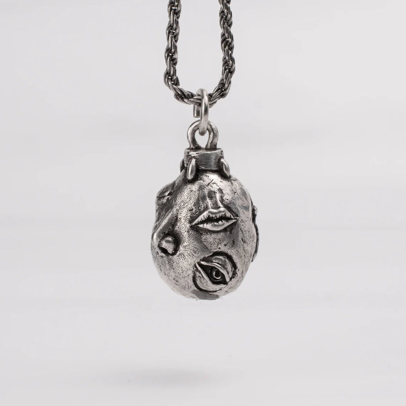 Handcrafted Behelit Jewelry – Berserk-inspired pendant necklace featuring Guts, Griffith, and God Hand symbolism with double-sided design: awakened face and sleeping face. High-quality pewter, hand-cast, unique imperfections, 22-inch (55.9 cm) stainless steel ball chain, secure lobster claw closure. Perfect for Berserk fans, anime collectors, dark fantasy lovers, cosplay, and unique gifts. Symbolic, collectible, artisan design.