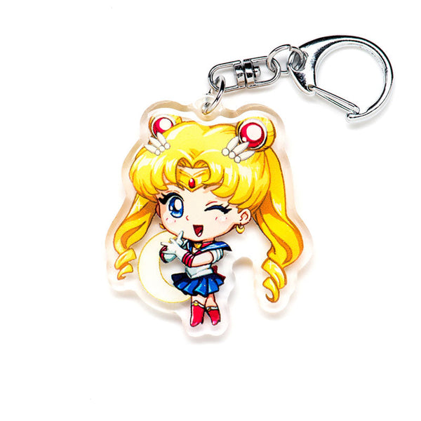 Charming Sailor Moon acrylic keychain with double-sided designs of Sailor Moon, Luna, and Tuxedo Mask. Featuring vibrant, scratch-resistant colors and a glitter epoxy coating. Perfect for accessorizing backpacks, lanyards, and Ita bags. Durable silver D-clasp ensures long-lasting quality. A magical collectible and the ideal gift for Sailor Moon fans and anime lovers!